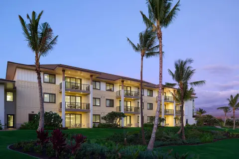 Exterior resort building and palms at dusk at Hilton Grand Vacations Club Maui Bay Villas.