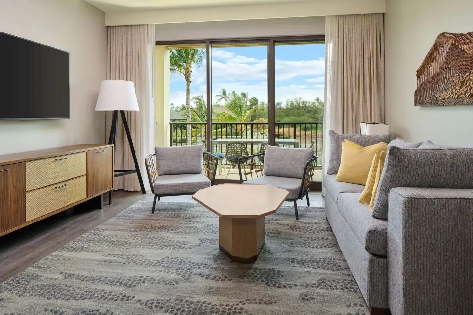 Living room with balcony and resort view at Hilton Grand Vacations Club Maui Bay Villas.