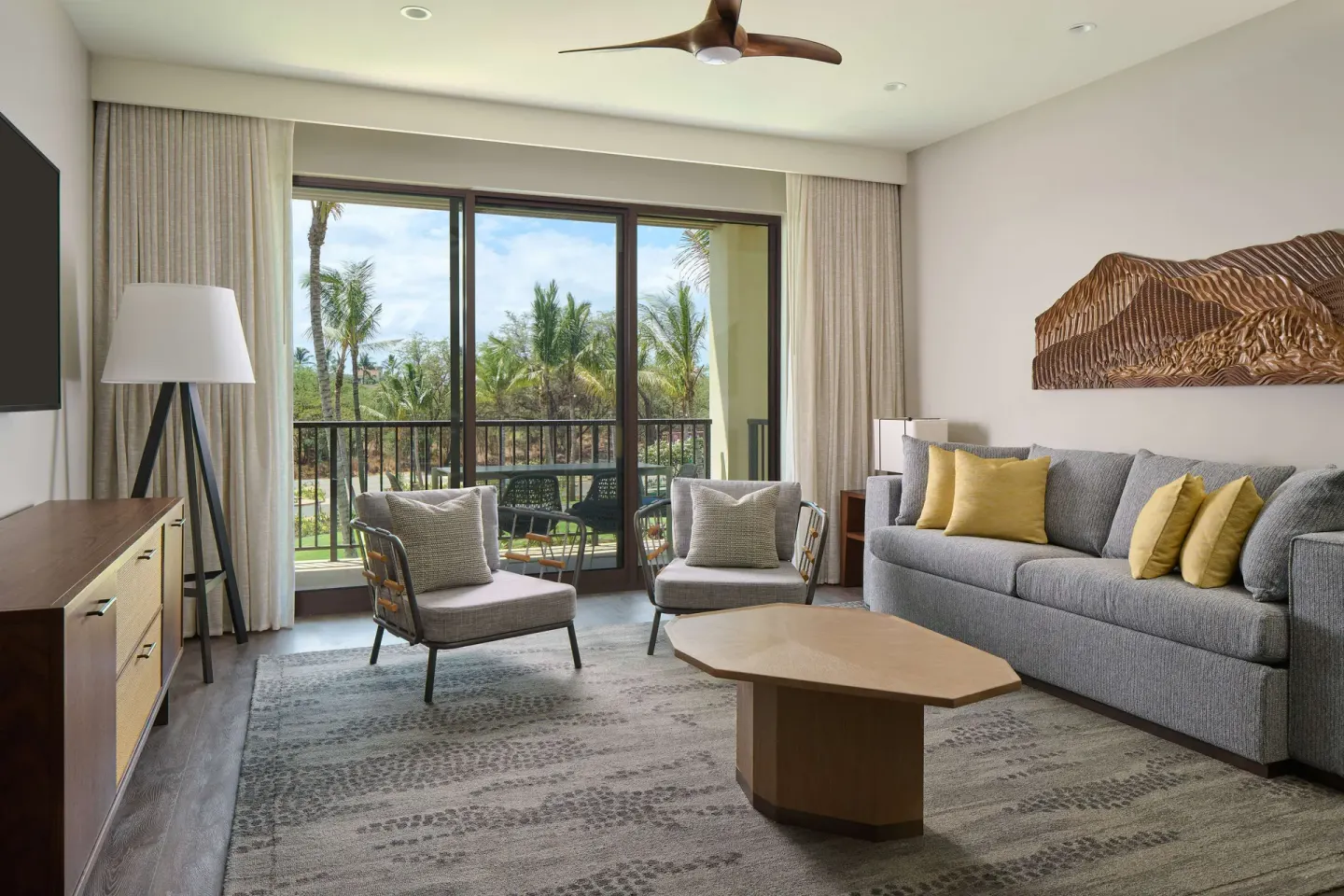 Living area with sofa and balcony in a 2 Bedroom suite at Hilton Grand Vacations Club Maui Bay Villas.