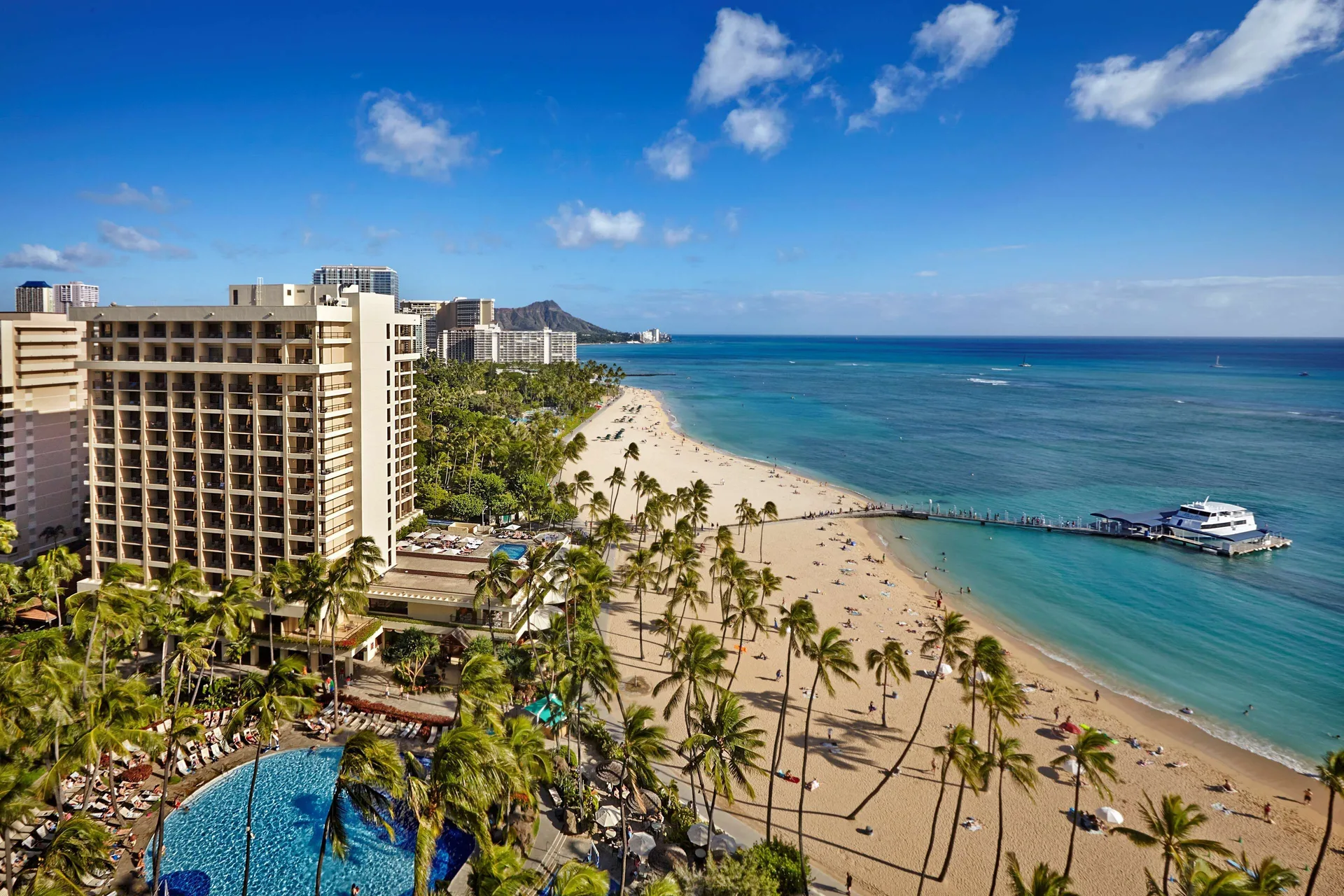 Beachfront towers, pool and Waikiki shoreline at Hilton Hawaiian Village Waikiki Beach Resort.