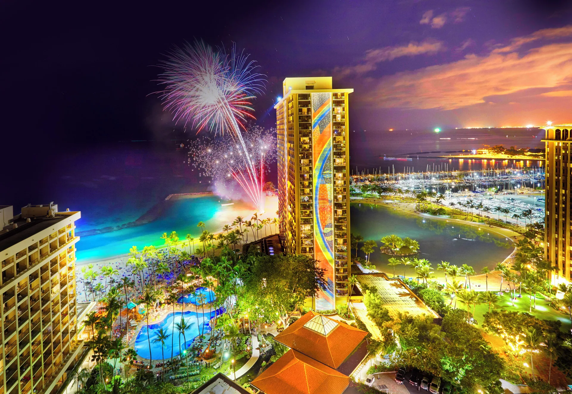 Fireworks over the resort towers and beach at Hilton Hawaiian Village Waikiki Beach Resort.