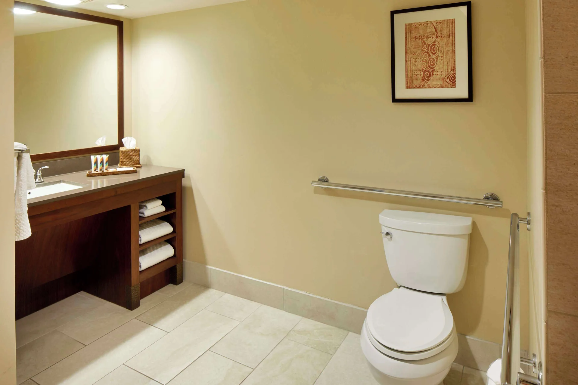 Guest bathroom vanity and toilet with grab bars at Hilton Hawaiian Village Waikiki Beach Resort.