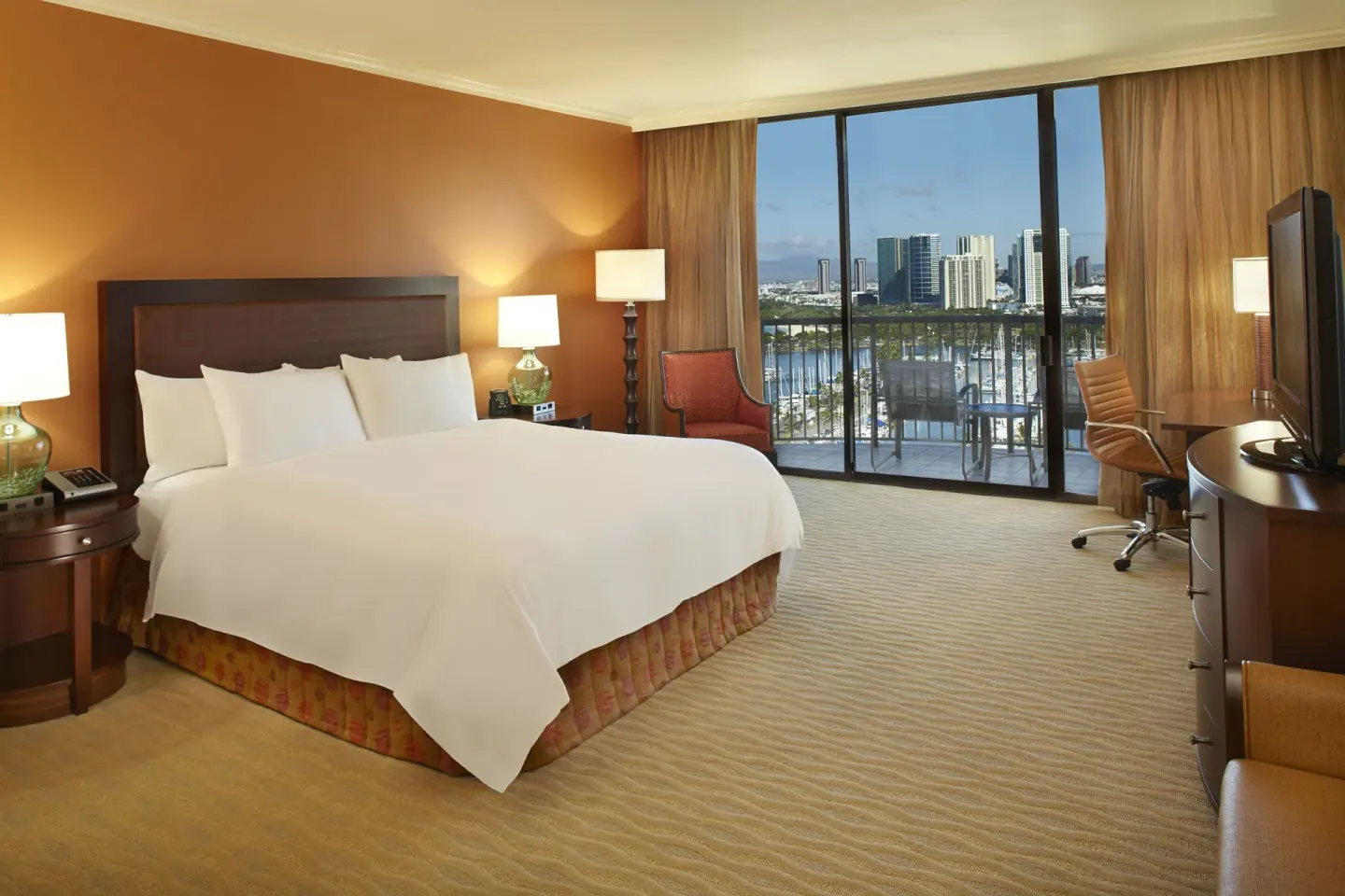 King-bed guest room with balcony and marina view at Hilton Hawaiian Village Waikiki Beach Resort.