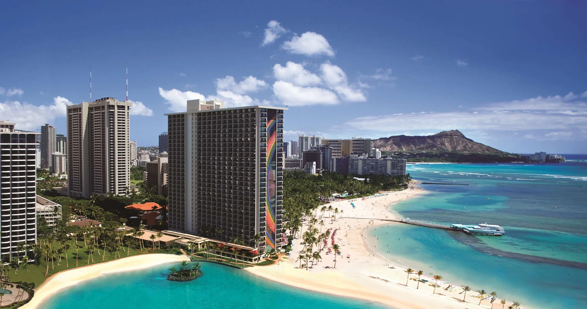 Resort lagoon, towers, beach and Diamond Head at Hilton Hawaiian Village Waikiki Beach Resort.