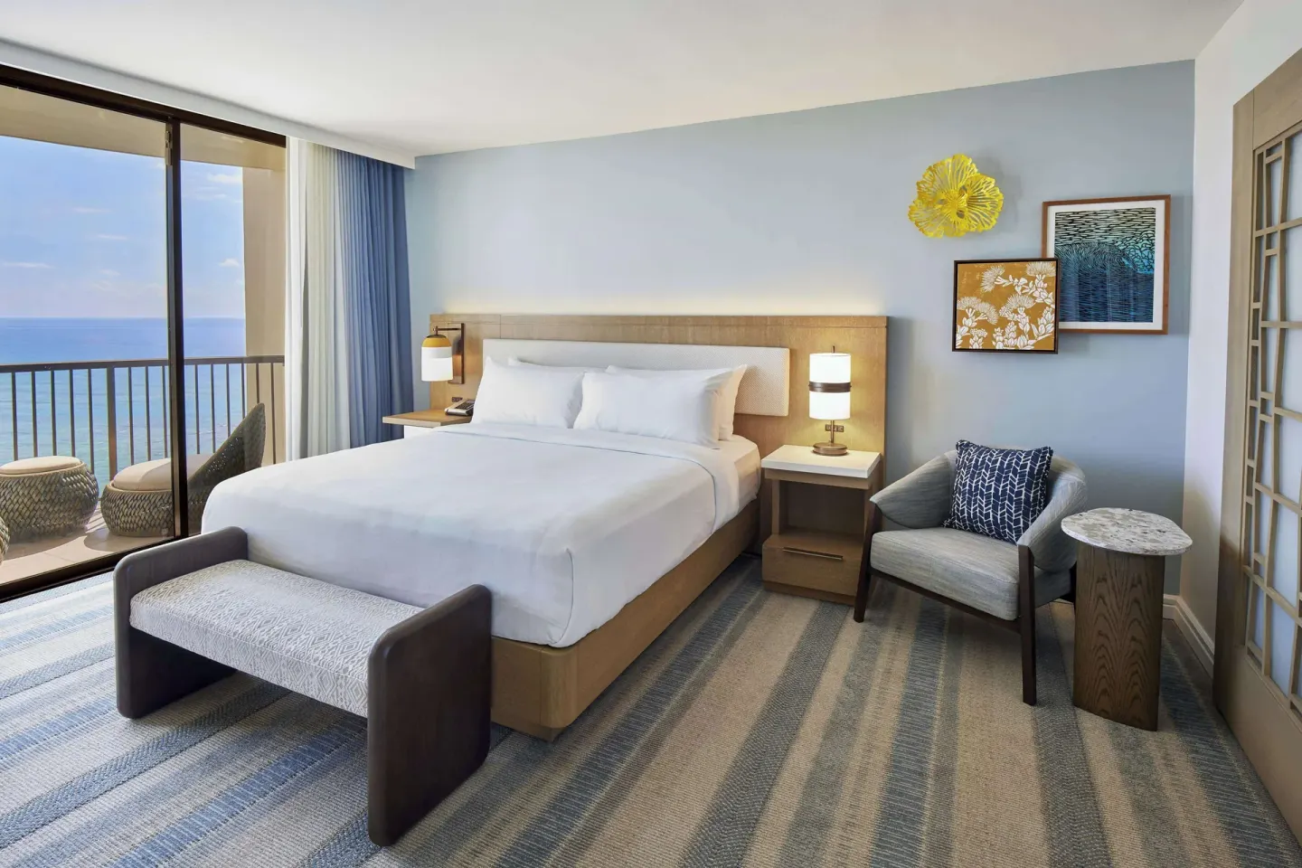 King guest room with ocean balcony and seating at Hilton Hawaiian Village Waikiki Beach Resort.