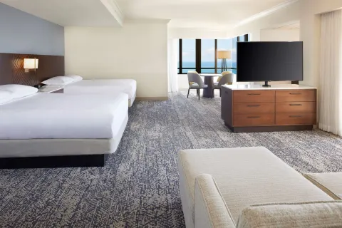 Two-bed ocean-view guest room with sitting area at Hilton Hawaiian Village Waikiki Beach Resort.