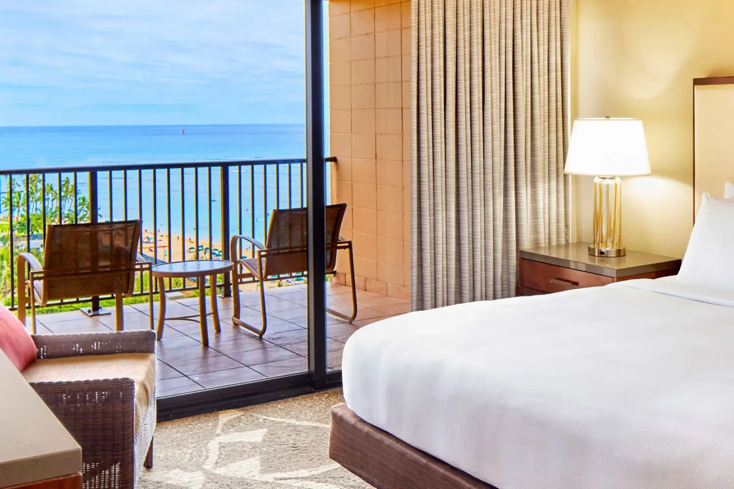Guest room with balcony overlooking Waikiki Beach at Hilton Hawaiian Village Waikiki Beach Resort.