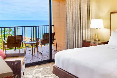 Guest room with balcony overlooking Waikiki Beach at Hilton Hawaiian Village Waikiki Beach Resort.