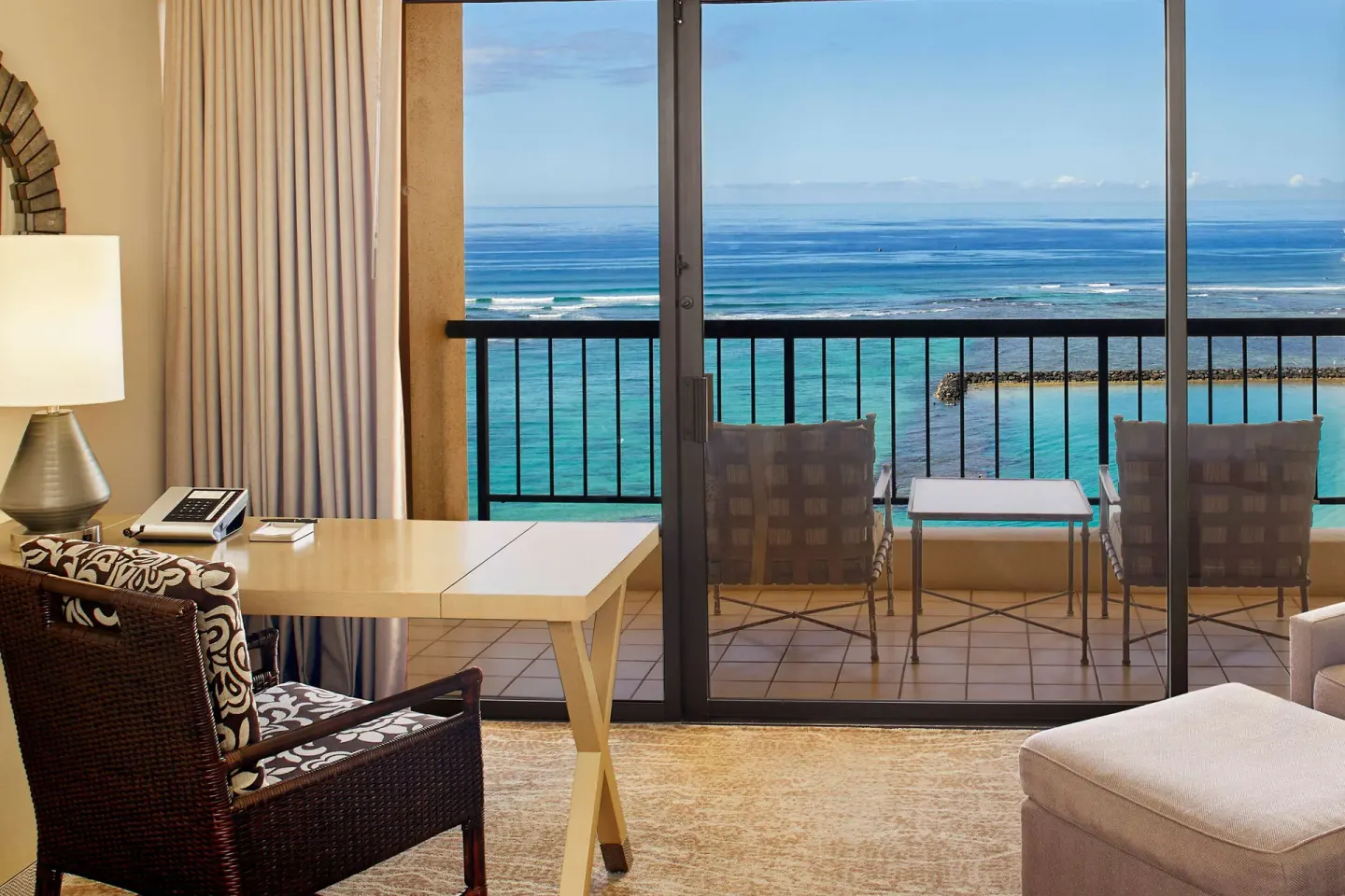 Oceanfront guest room balcony with reef and lagoon views at Hilton Hawaiian Village Waikiki Beach Resort.