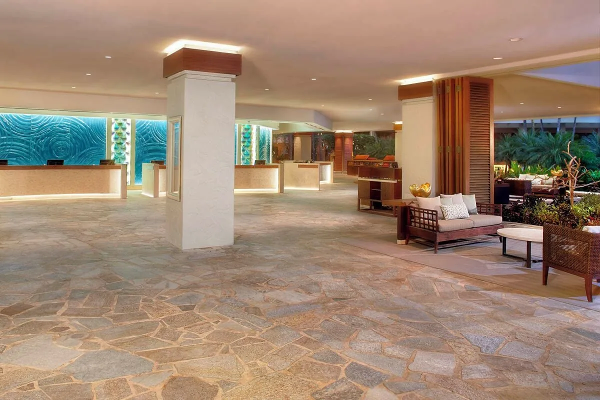 Open-air lobby with reception desks and lounge seating at Hilton Hawaiian Village Waikiki Beach Resort.