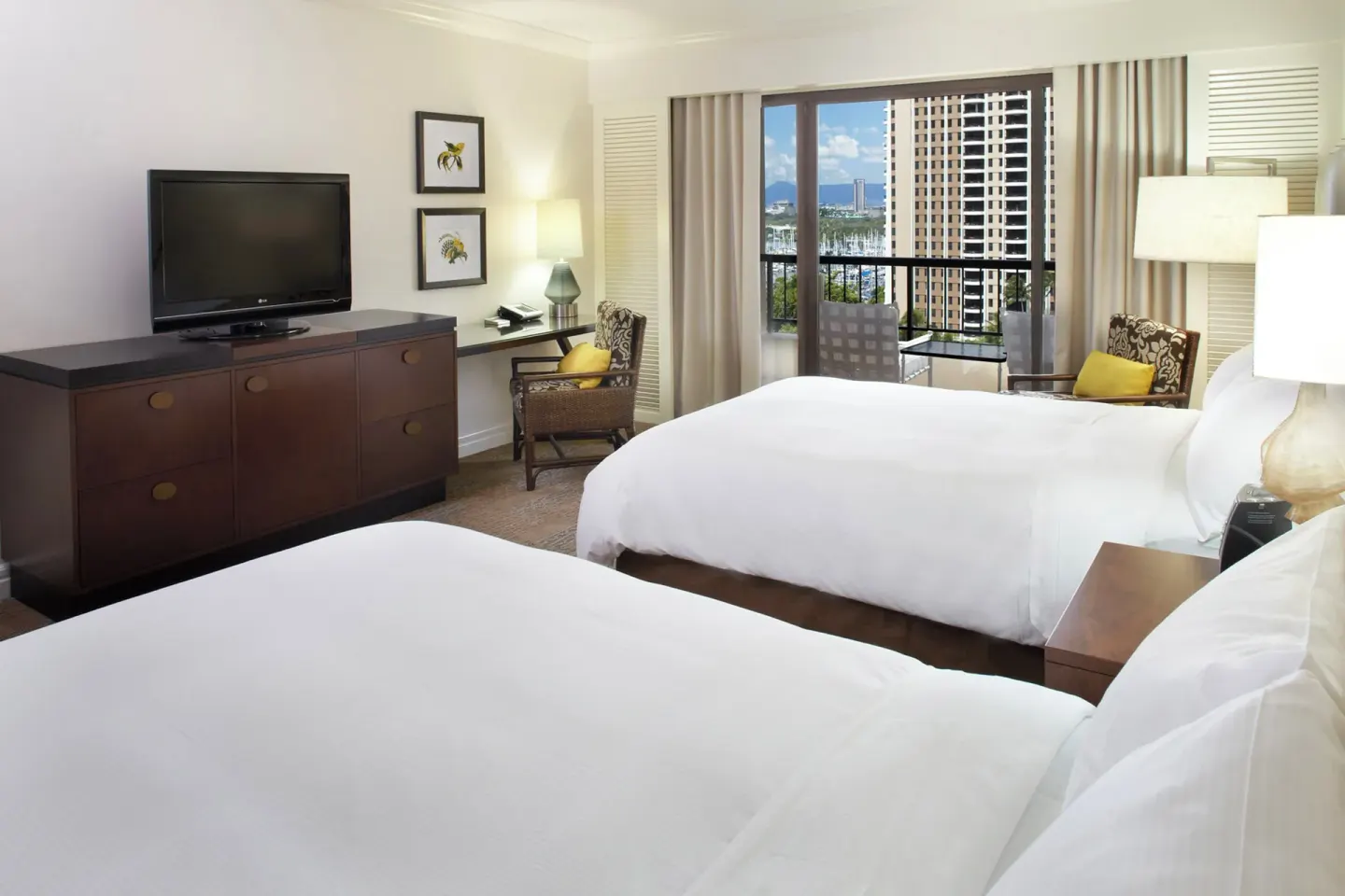 Two-bed guest room with TV and city-facing balcony at Hilton Hawaiian Village Waikiki Beach Resort.