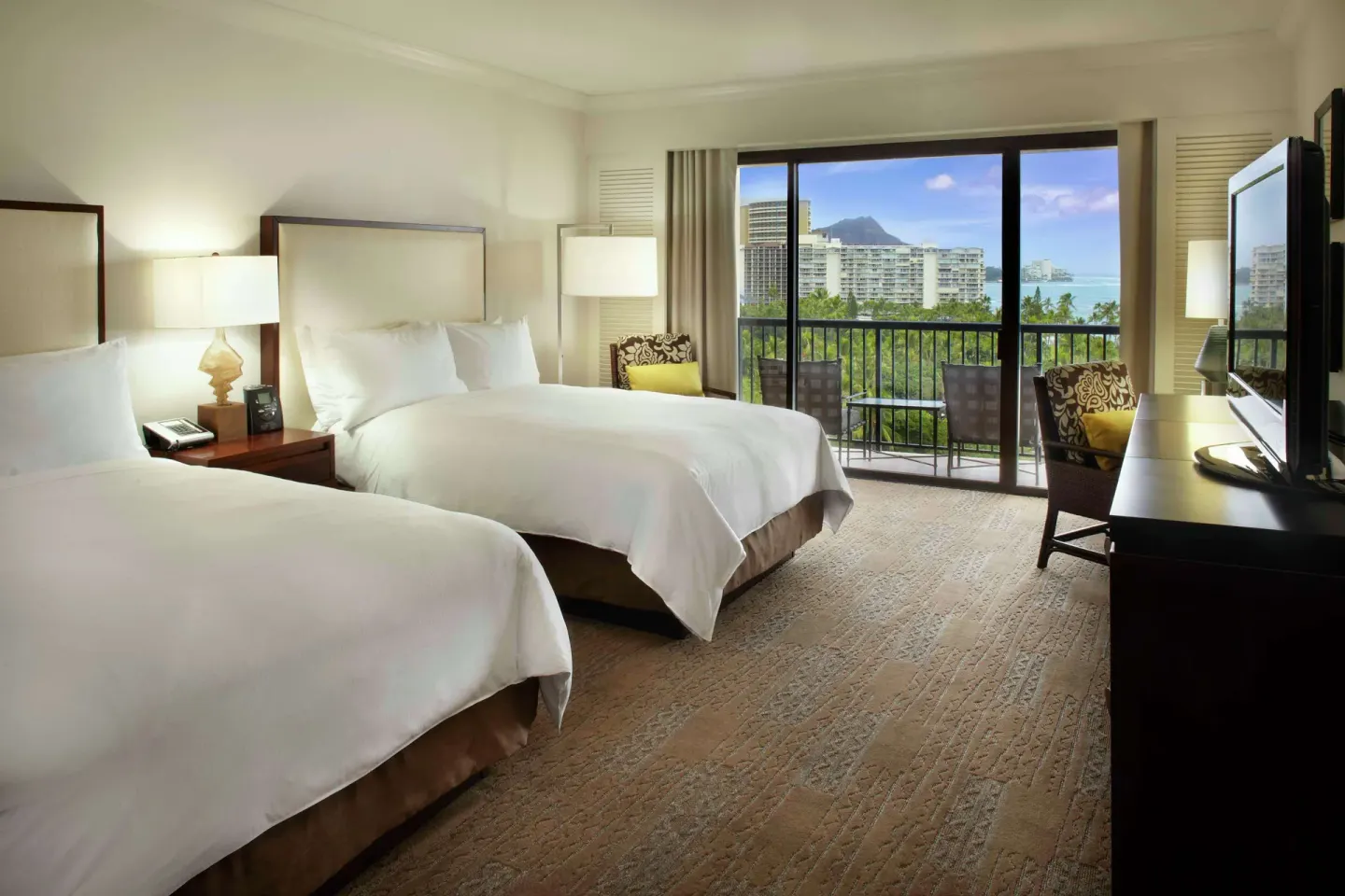 Two-bed guest room with balcony view toward Diamond Head at Hilton Hawaiian Village Waikiki Beach Resort.