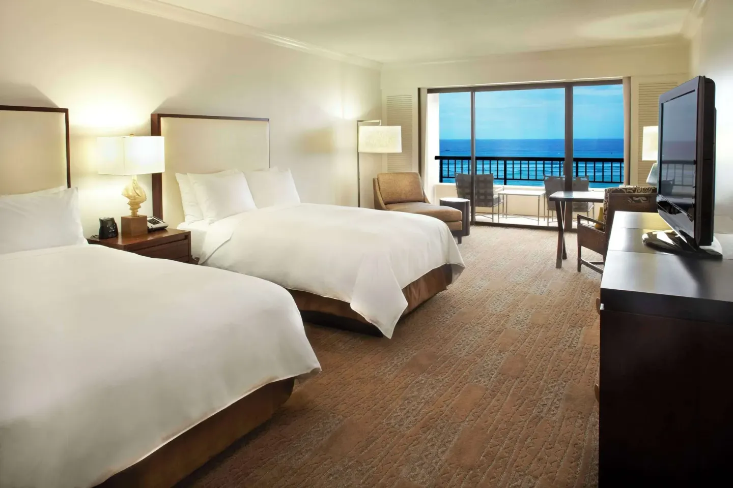 Two-bed ocean-view guest room with balcony at Hilton Hawaiian Village Waikiki Beach Resort.