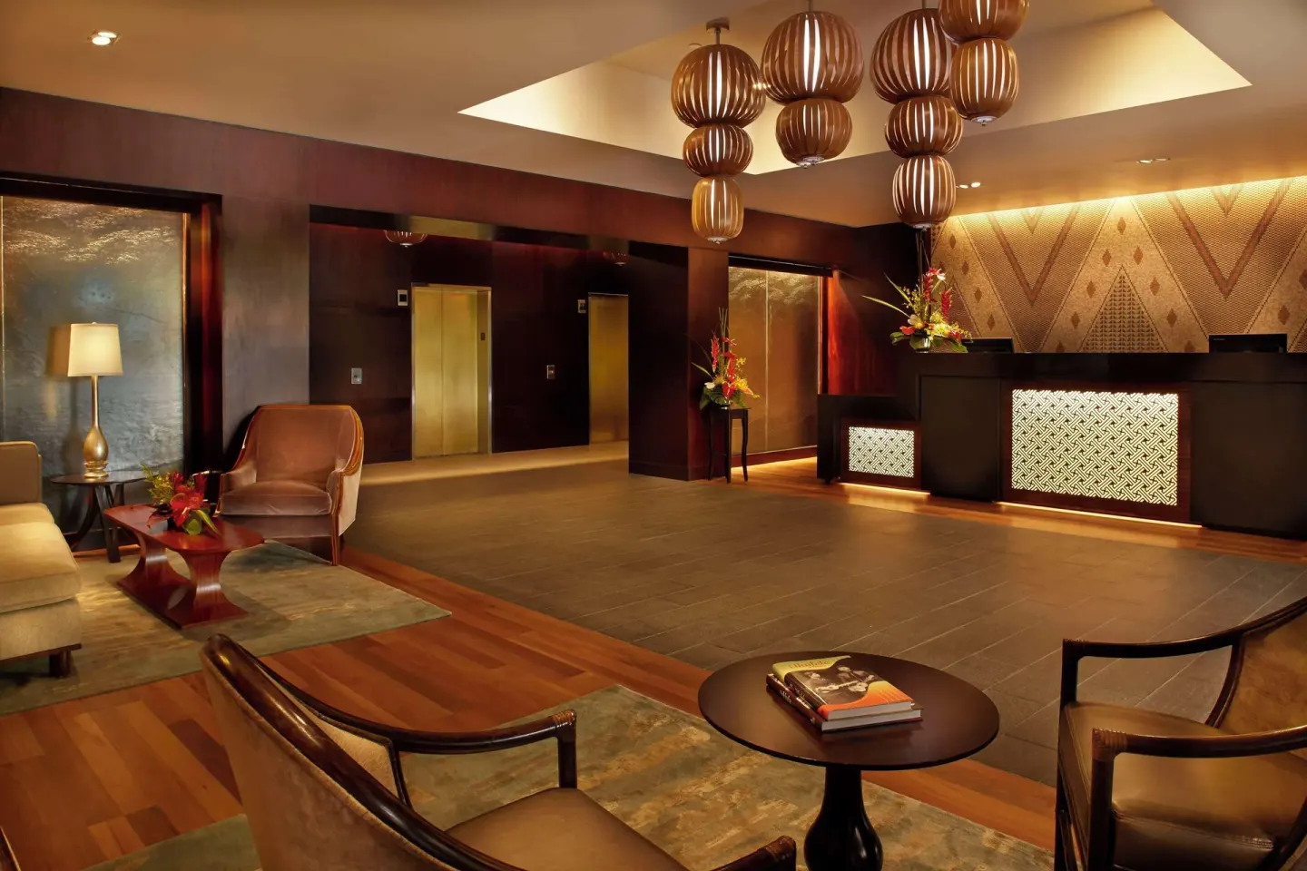 Warm lobby seating area and front desk at Hilton Hawaiian Village Waikiki Beach Resort.