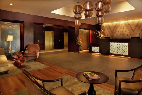 Warm lobby seating area and front desk at Hilton Hawaiian Village Waikiki Beach Resort.