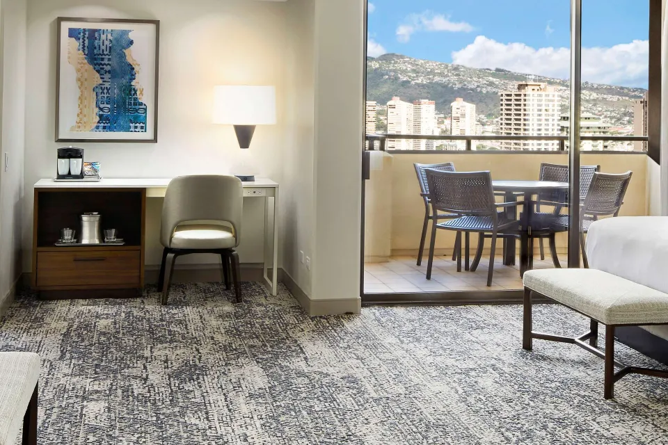 Family Room desk, bed edge, and balcony seating at Hilton Hawaiian Village Waikiki Beach Resort.