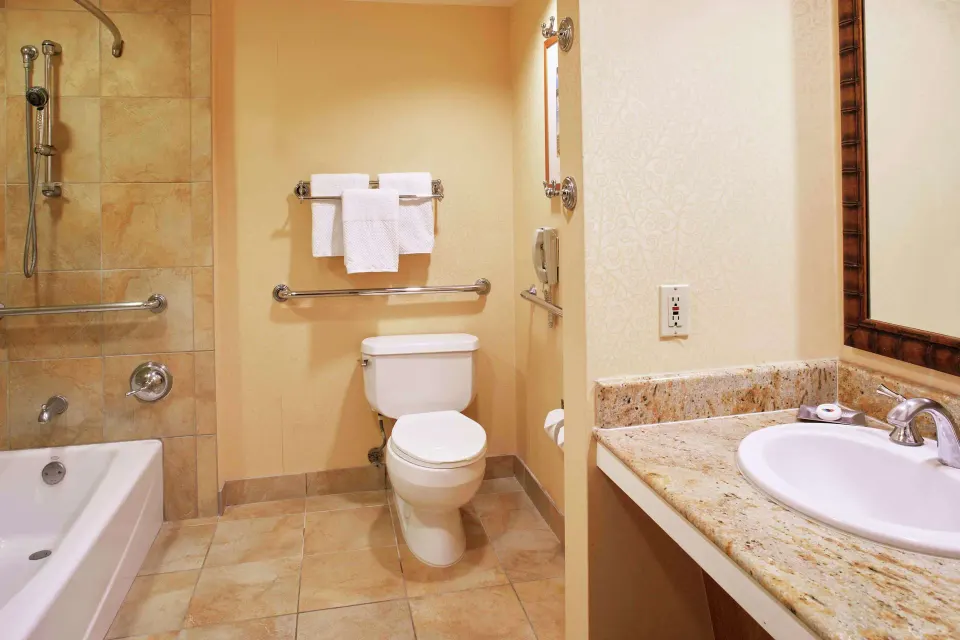Accessible bathroom with tub, grab bars, toilet and vanity at Hilton Hawaiian Village Waikiki Beach Resort.