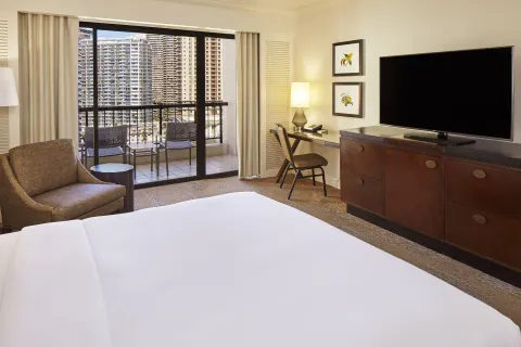Accessible guest room with king bed, balcony, desk, and TV at Hilton Hawaiian Village Waikiki Beach Resort.
