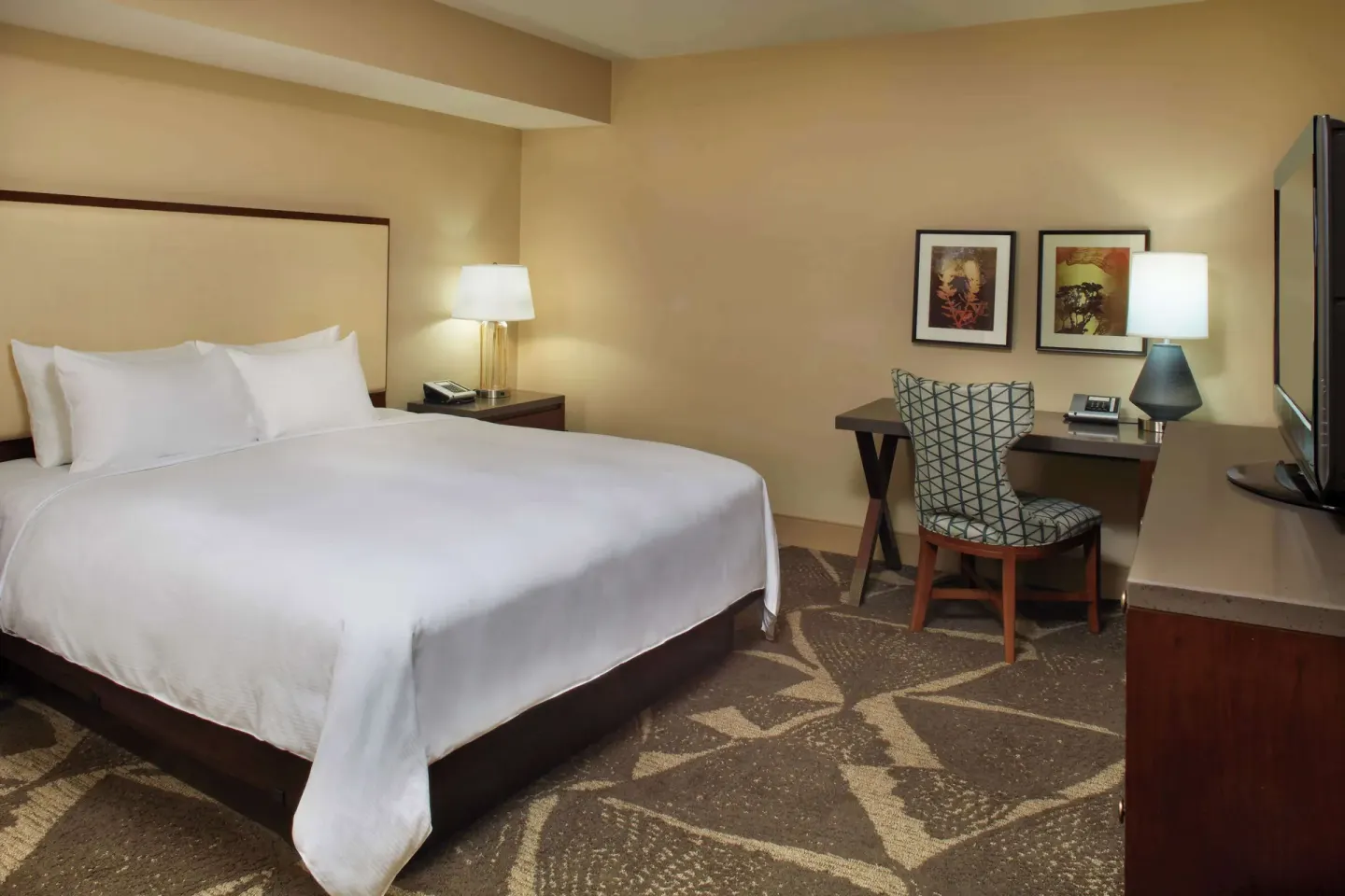 Accessible guest room with king bed, desk, lamps, and TV at Hilton Hawaiian Village Waikiki Beach Resort.