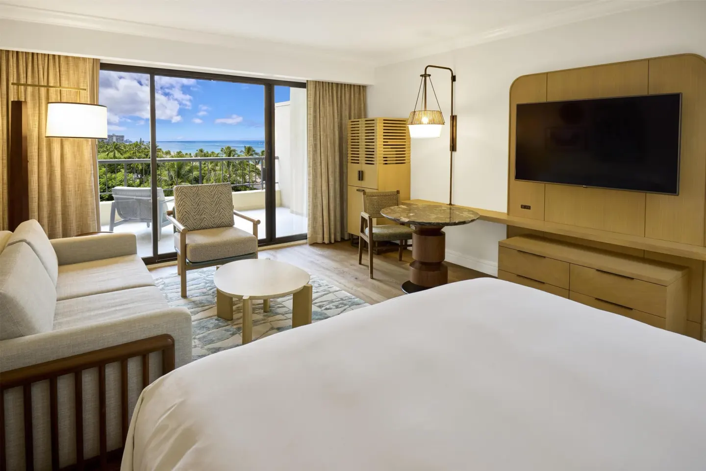 Ocean View Alii Tower room with king bed and balcony at Hilton Hawaiian Village Waikiki Beach Resort.