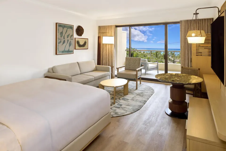 Ocean View Alii Tower king room seating area and balcony at Hilton Hawaiian Village Waikiki Beach Resort.