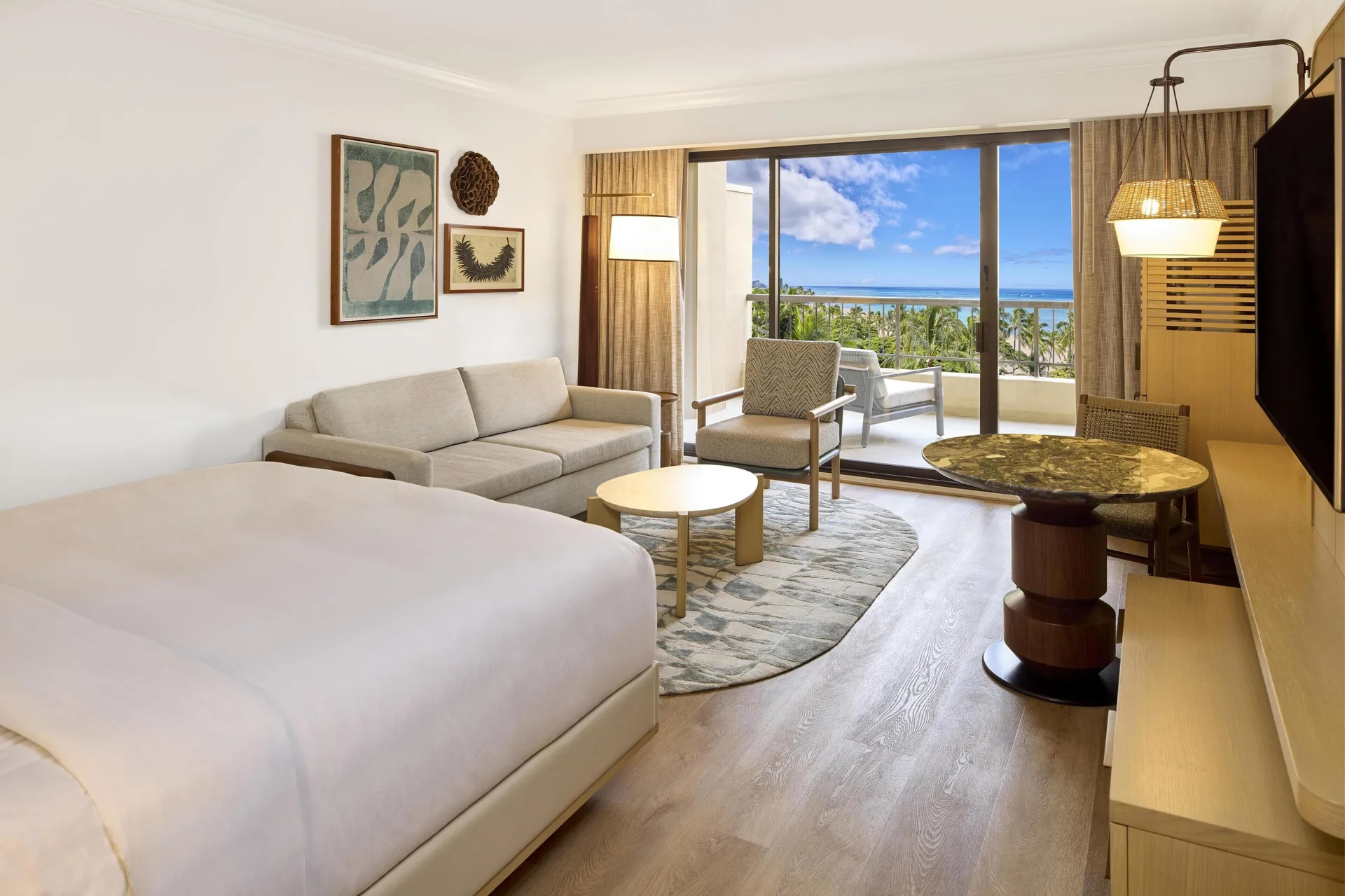 Ocean View Alii Tower king room seating area and balcony at Hilton Hawaiian Village Waikiki Beach Resort.
