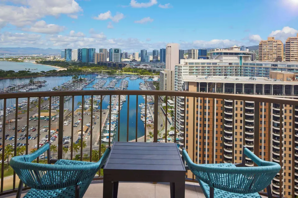 Balcony view from Hilton Hawaiian Village Waikiki Beach Resort over marina, city towers, and ocean.