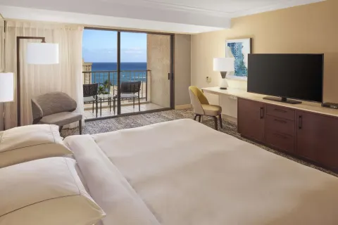 King bed ocean view room with TV, desk, and balcony at Hilton Hawaiian Village Waikiki Beach Resort.