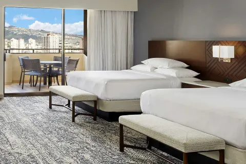 Two-bed ocean view guest room with balcony at Hilton Hawaiian Village Waikiki Beach Resort.
