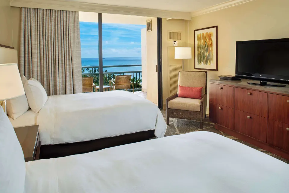 Two-bed Ocean View room with balcony and TV at Hilton Hawaiian Village Waikiki Beach Resort.