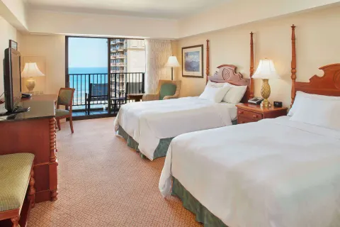 Two-bed Ocean View room with wood furniture at Hilton Hawaiian Village Waikiki Beach Resort.