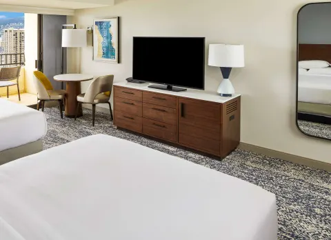 Resort-view guest room TV area and beds at Hilton Hawaiian Village Waikiki Beach Resort.