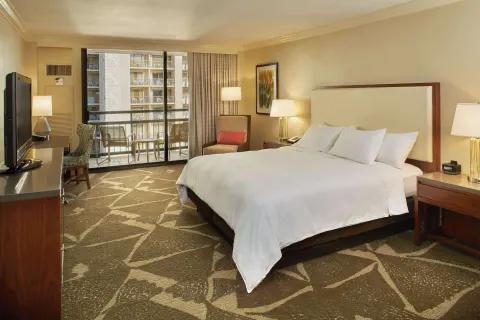 Resort view room with king bed, balcony, and seating area at Hilton Hawaiian Village Waikiki Beach Resort.