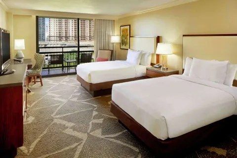 Bright two-bed guest room with resort-view balcony at Hilton Hawaiian Village Waikiki Beach Resort.