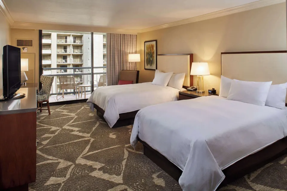 Resort view room with two beds, TV, and balcony at Hilton Hawaiian Village Waikiki Beach Resort.