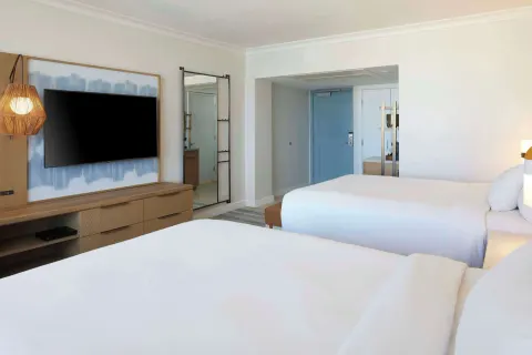 Two-bed resort-view guest room at Hilton Hawaiian Village Waikiki Beach Resort with TV and entry area.