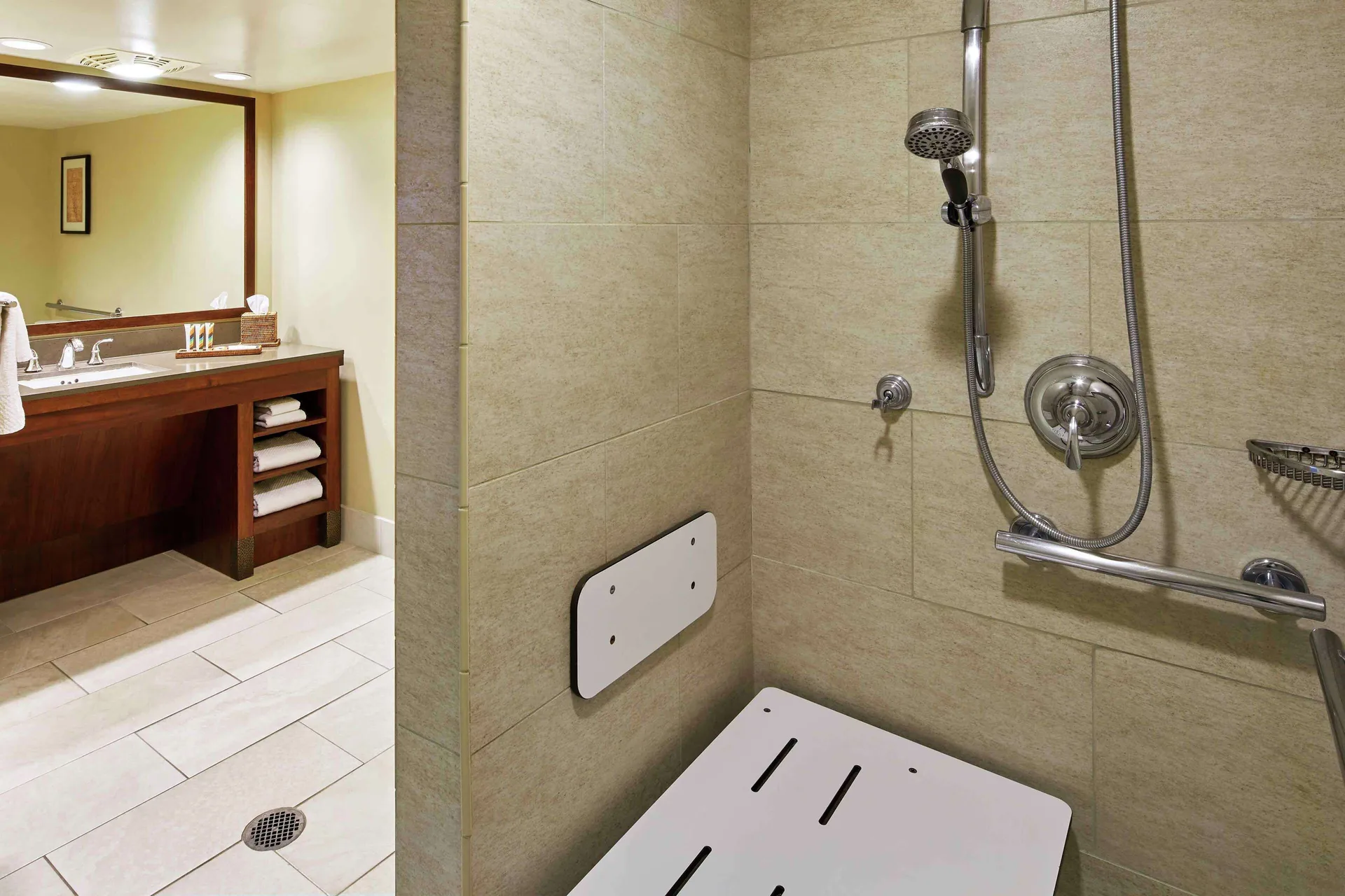 Roll-in shower and bathroom vanity in a room at Hilton Hawaiian Village Waikiki Beach Resort.