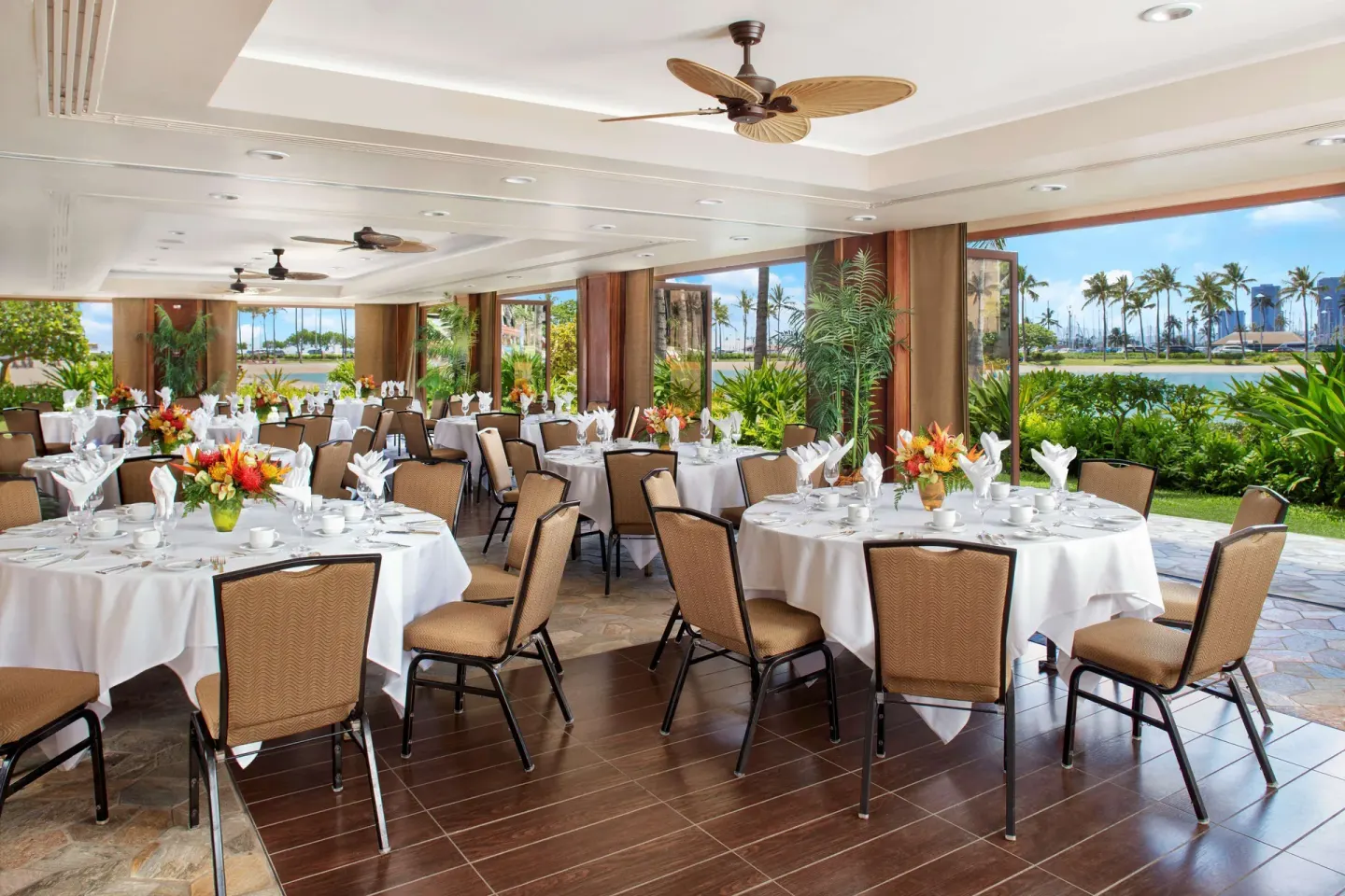Open-air banquet room with round tables at Hilton Hawaiian Village Waikiki Beach Resort.