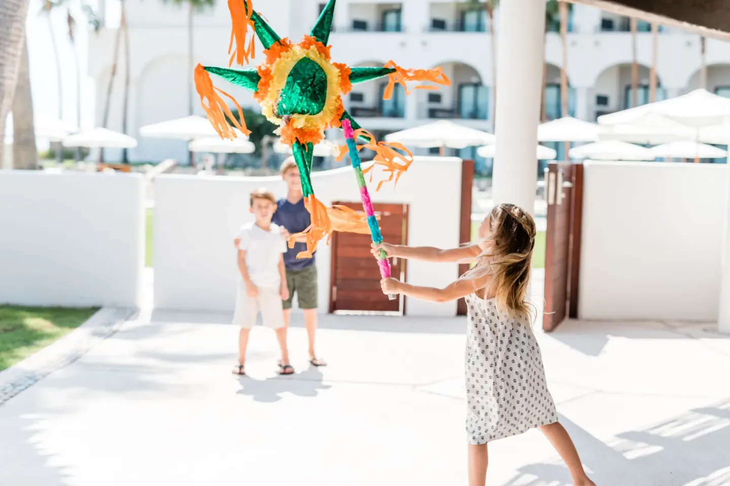 Children playing with a colorful piñata outdoors at Hilton Los Cabos.