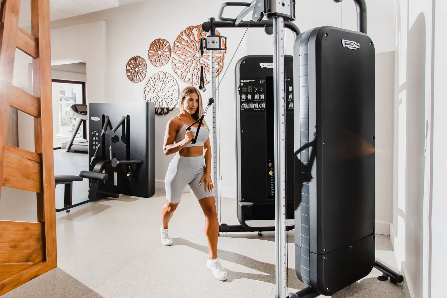 Guest using a cable machine in the fitness center at Hilton Los Cabos.