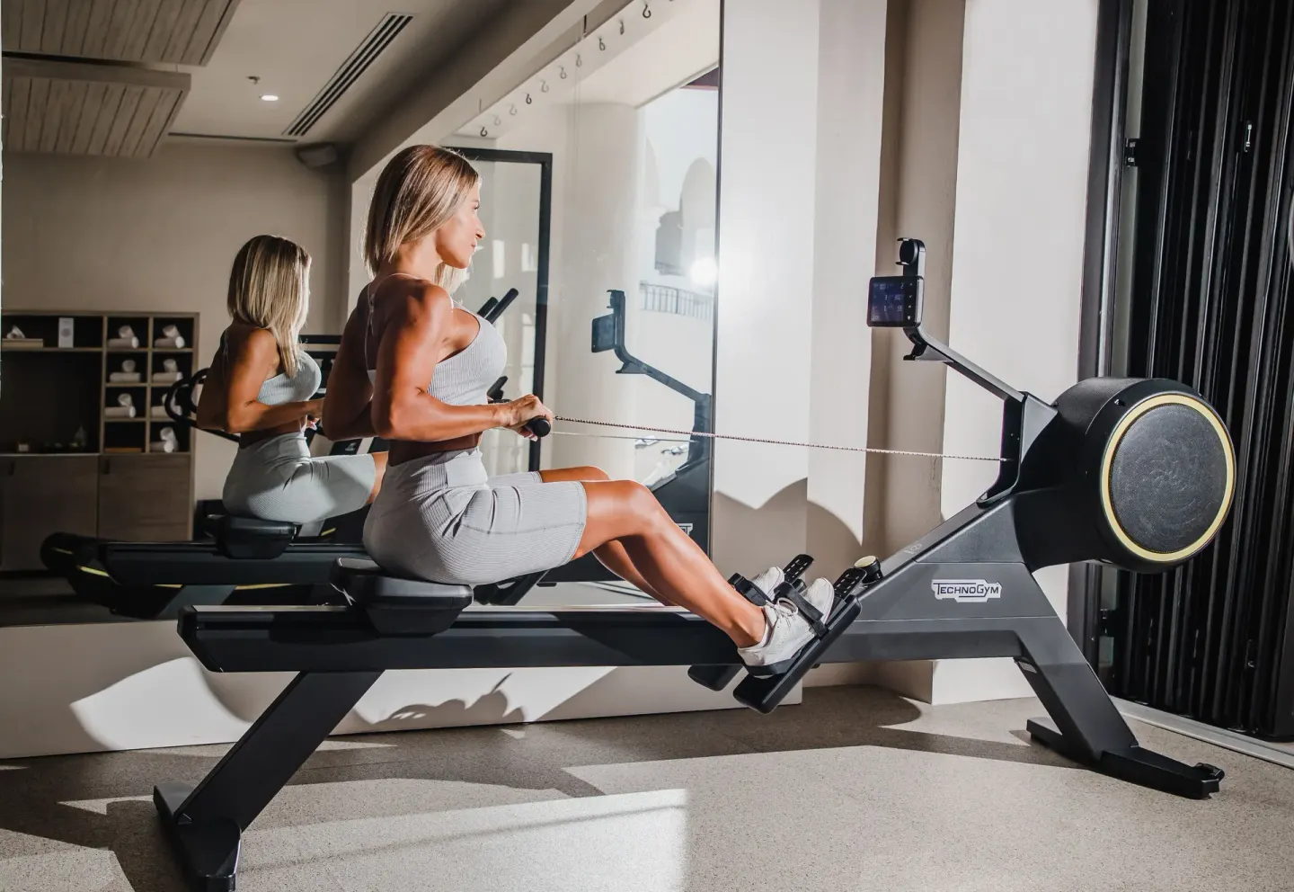 Guest using a rowing machine in the fitness center at Hilton Los Cabos.