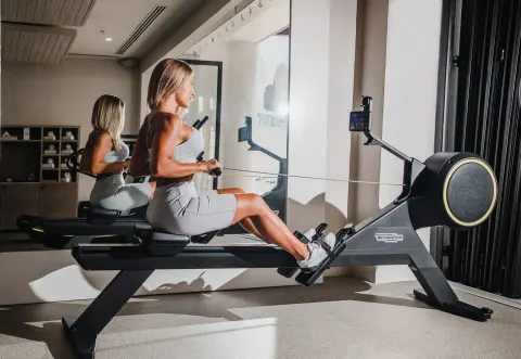 Guest using a rowing machine in the fitness center at Hilton Los Cabos.