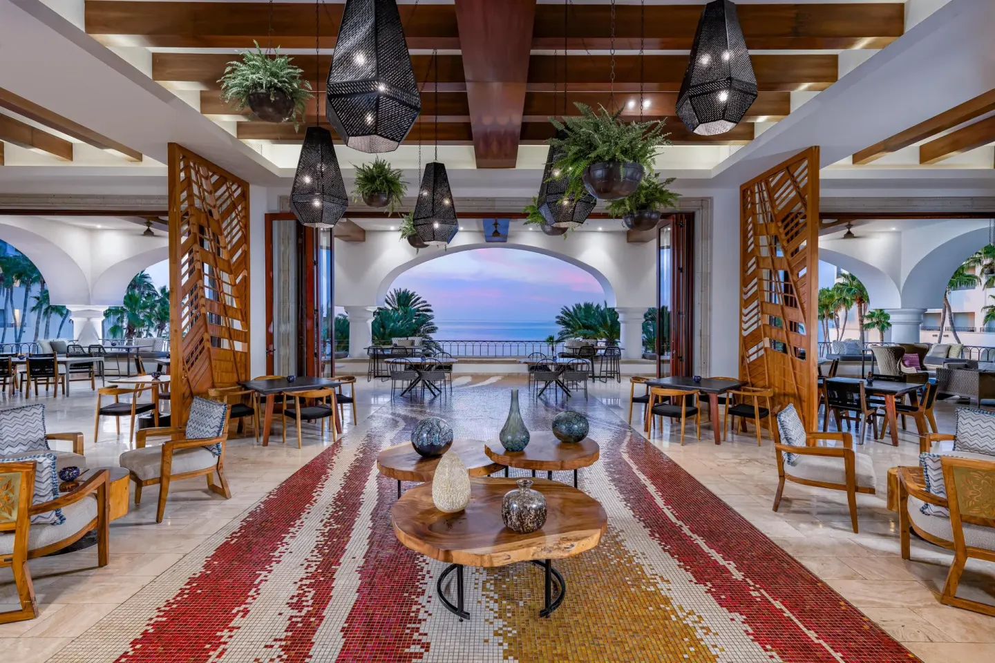 Lobby seating area with hanging lanterns and ocean view at Hilton Los Cabos.