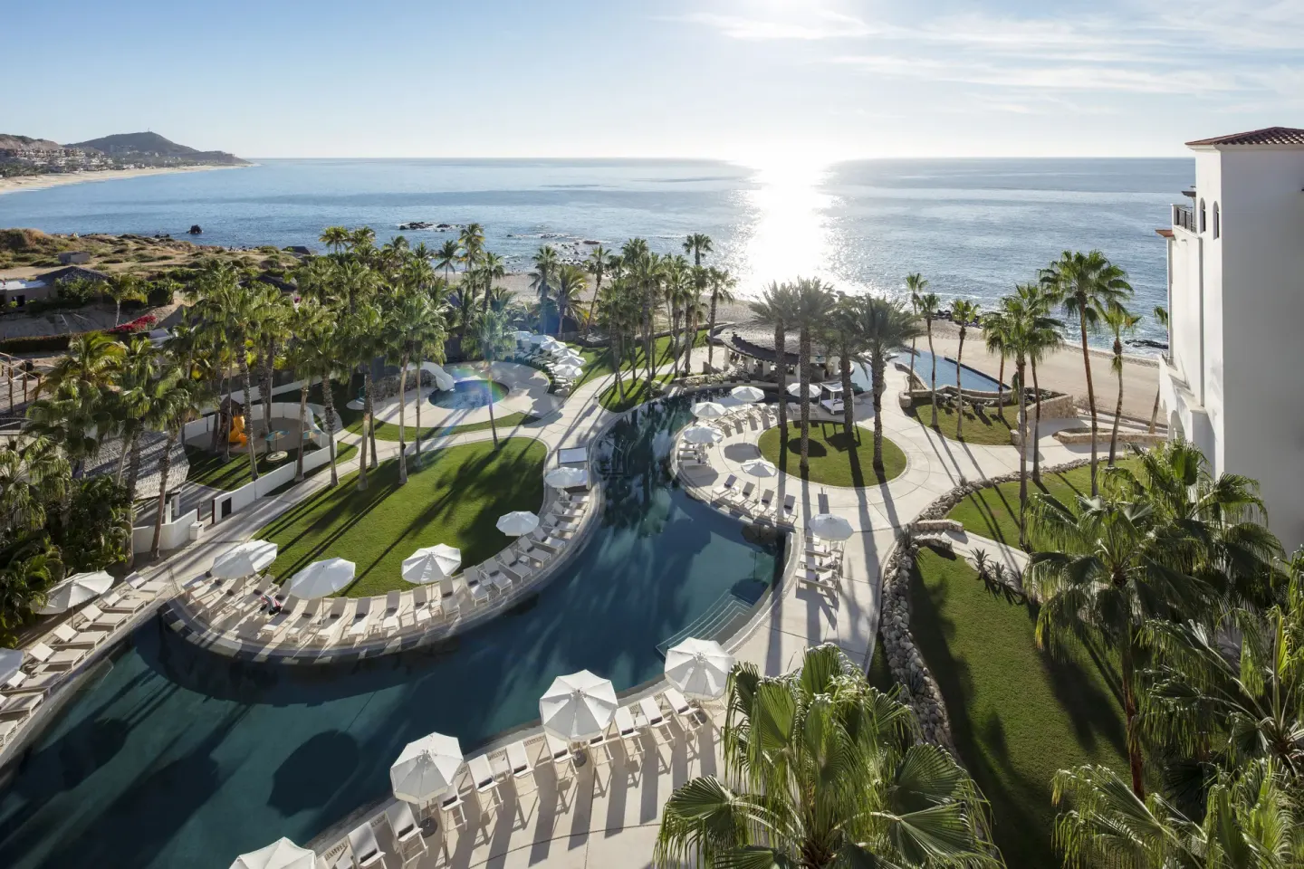 Aerial view of pools, palms, lawns and oceanfront at Hilton Los Cabos.