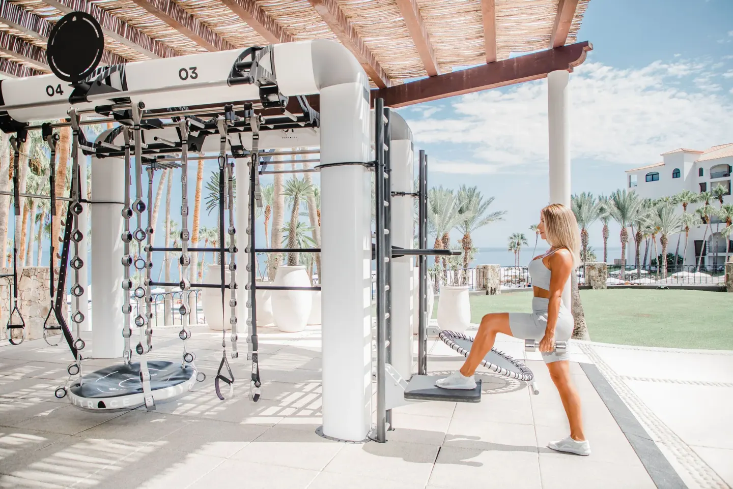Outdoor fitness equipment with a guest exercising at Hilton Los Cabos.