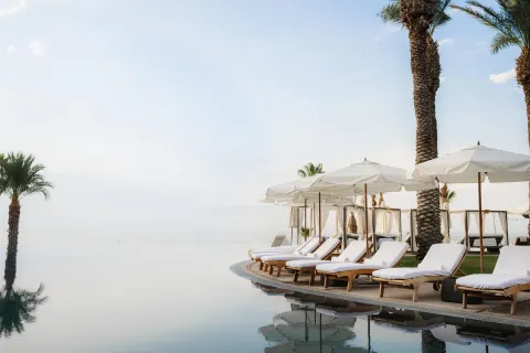 Poolside loungers and umbrellas beside an infinity-edge pool at Hilton Los Cabos.