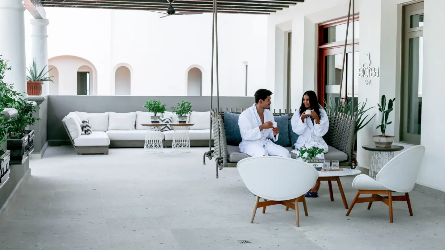 Guests in robes relaxing in the spa lounge at Hilton Los Cabos.