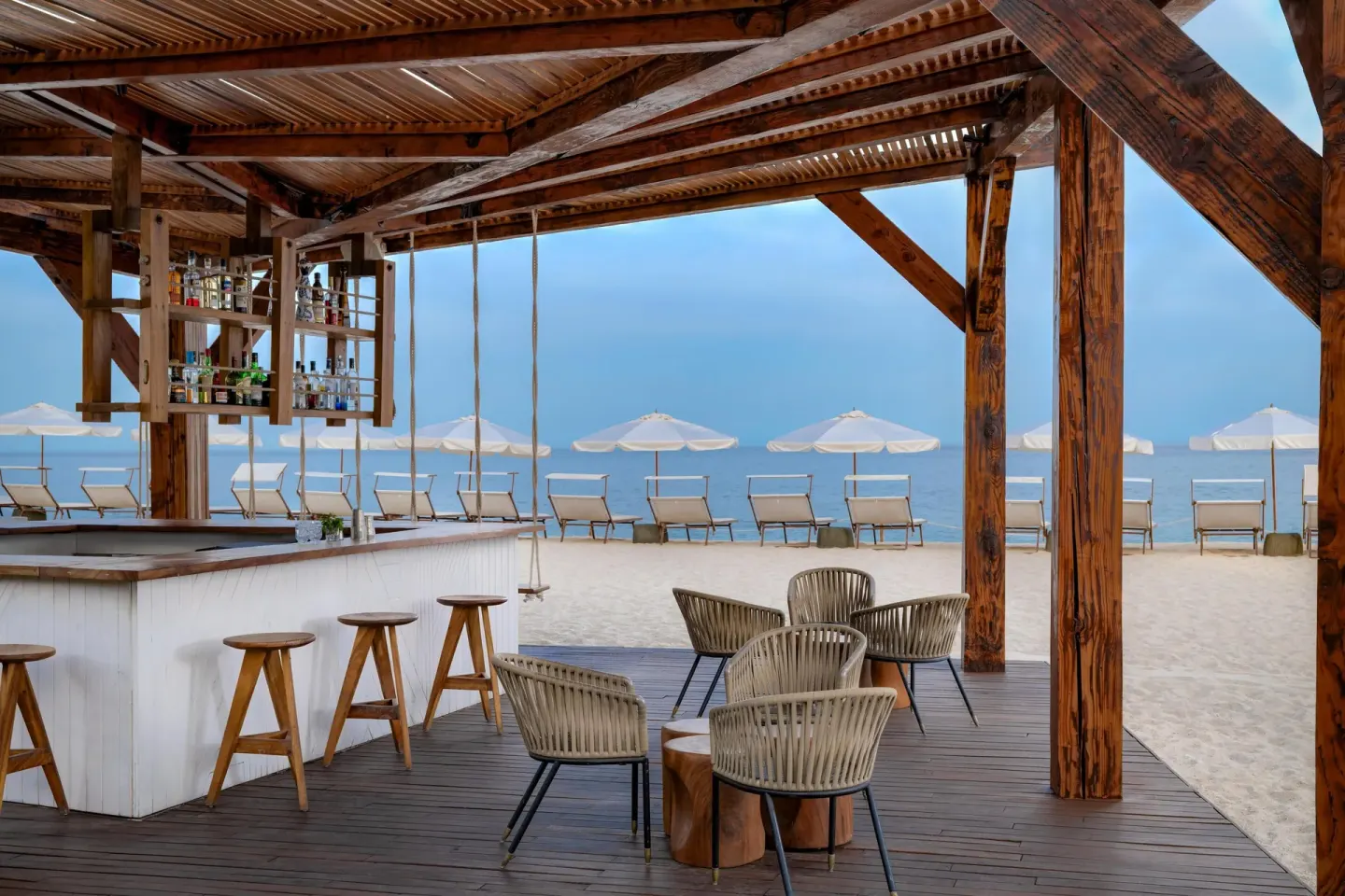 Beach bar seating and umbrellas facing the ocean at Hilton Los Cabos.