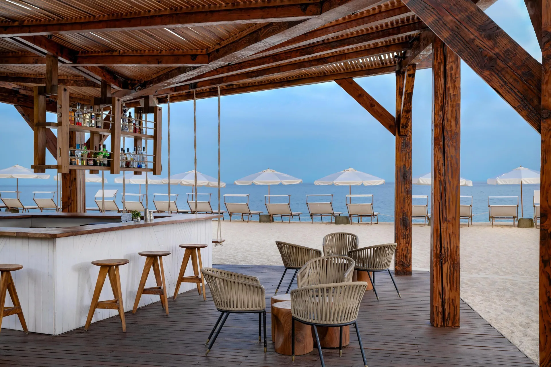 Beach bar seating and umbrellas facing the ocean at Hilton Los Cabos.