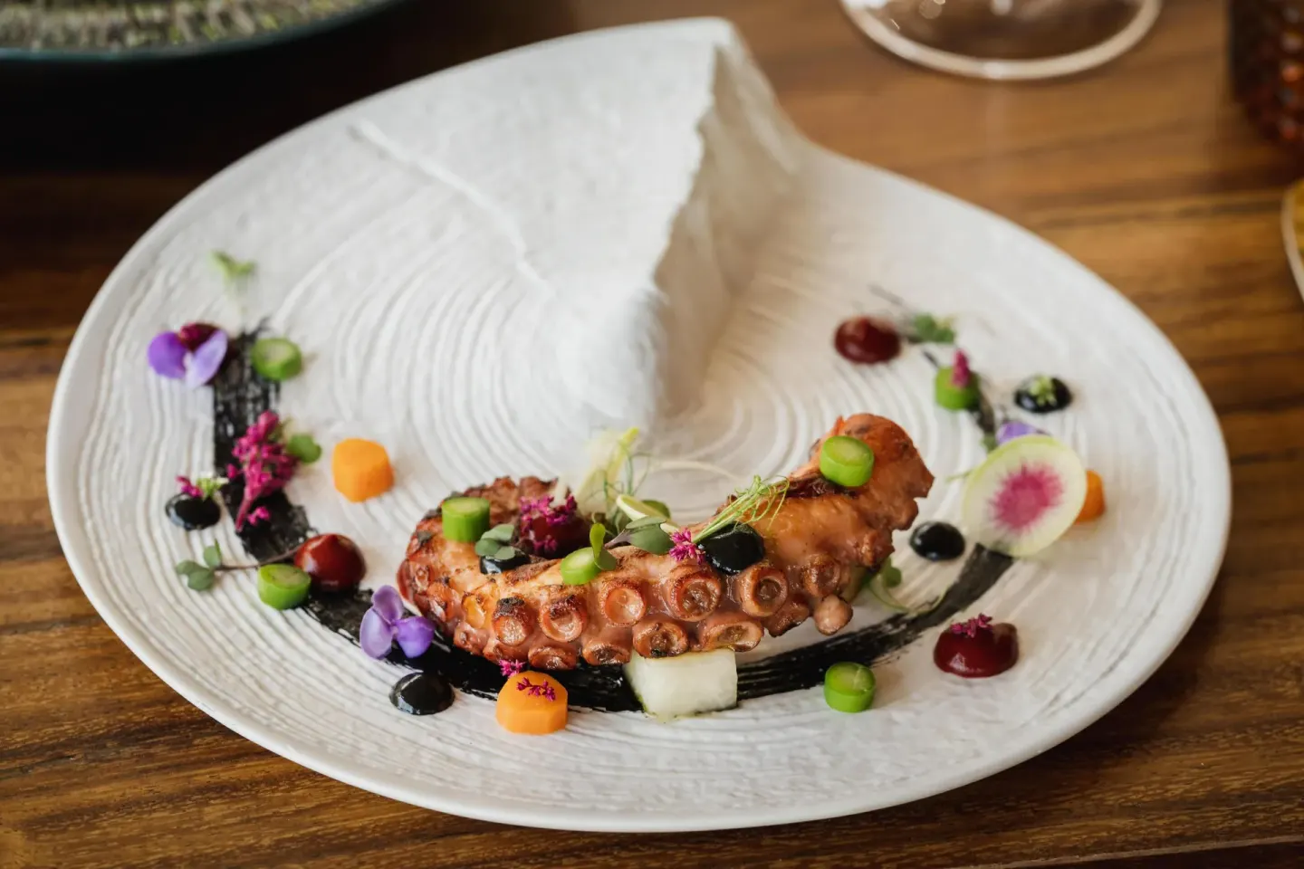 Plated grilled octopus with colorful garnishes at Hilton Los Cabos.